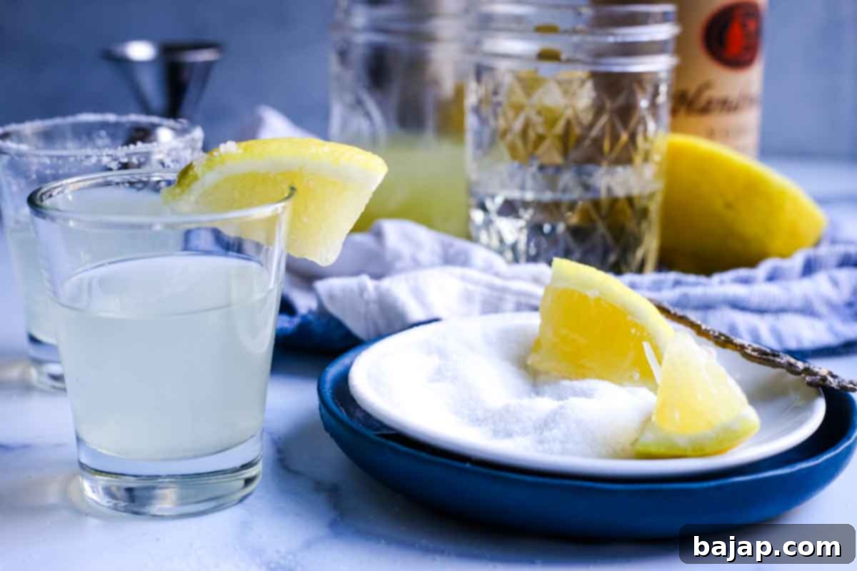 Several Lemon Drop Shots, garnished with sugar rims and lemon slices.