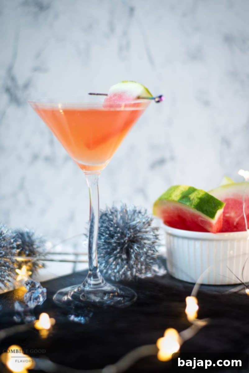 Gorgeous watermelon martini with a watermelon garnish, placed on a black slate plate, ready to be enjoyed on a warm day.