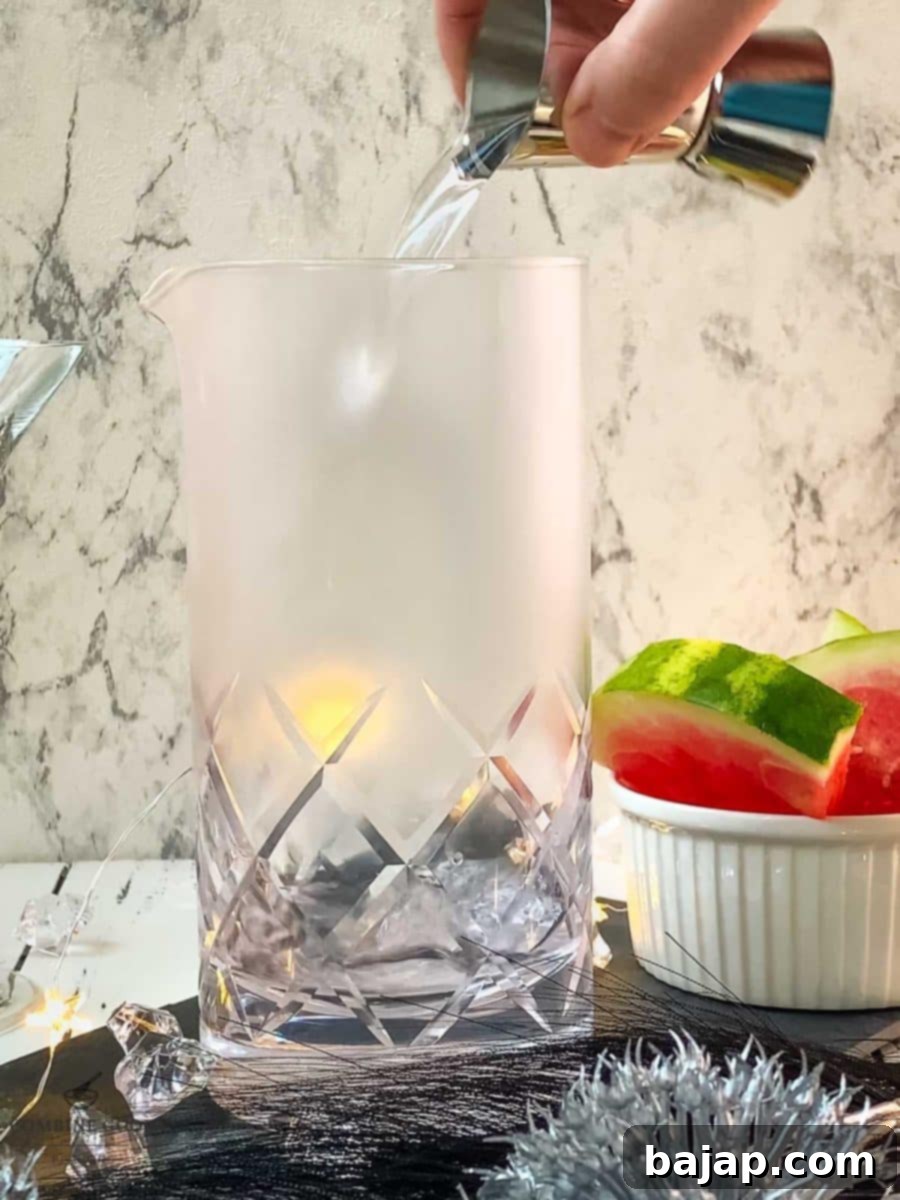 Adding vodka and dry vermouth into the stirring glass, the clear liquids mixing.