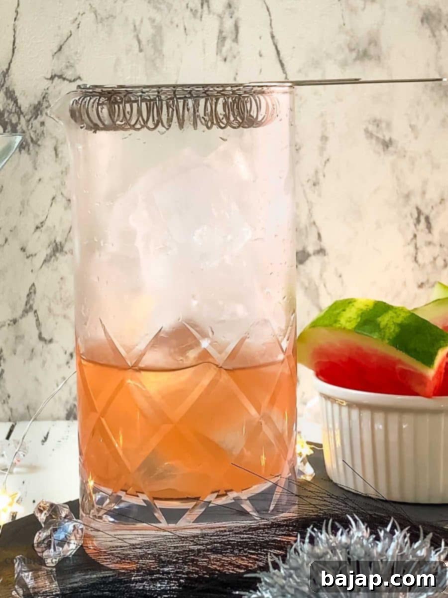 The hawthorn strainer is placed on top of the stirring glass, ready to pour the martini.