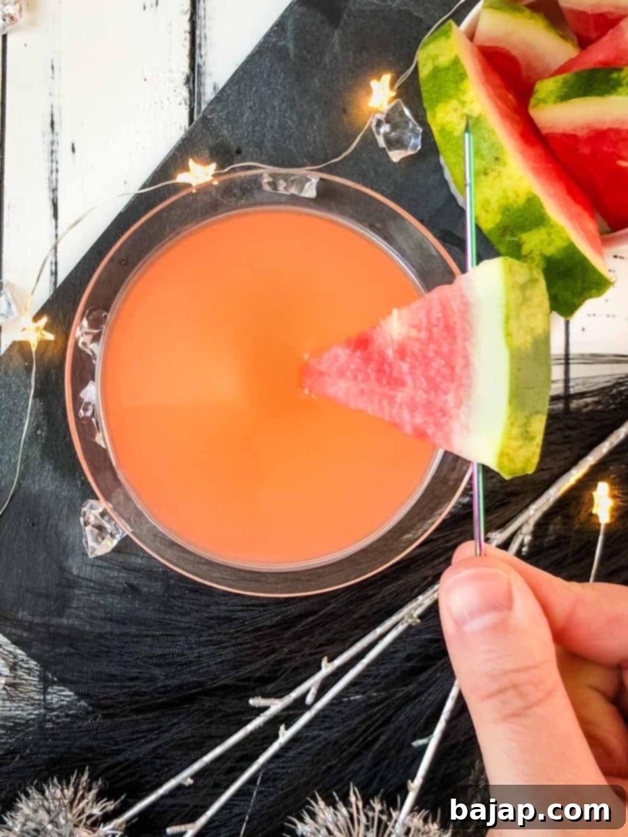 Place a watermelon slice into the drink using a cocktail pike, adding a decorative and flavorful garnish.