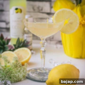 Gorgeous Limoncello Martini cocktail with elderflower syrup. Garnished with a lemon slice and placed on a mirrored coaster.
