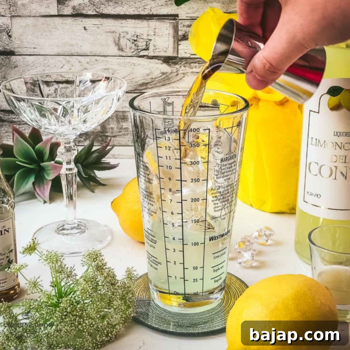 A clear, golden elderflower syrup being added to the cocktail shaker, promising a delicate floral sweetness.