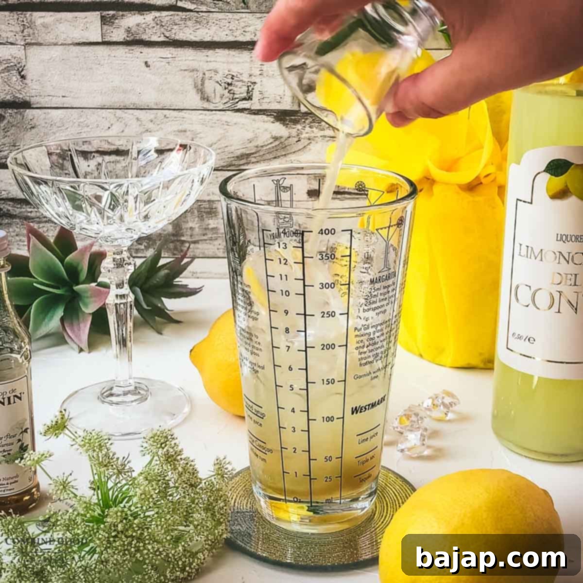 Freshly squeezed lemon juice being poured into the cocktail shaker, adding a crucial tart and bright element.
