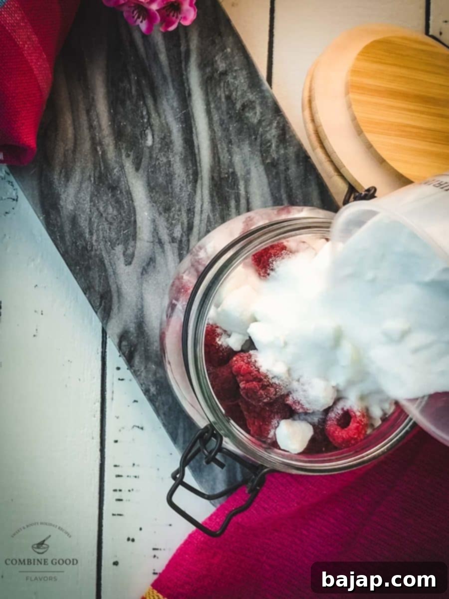 Filling the granulated sugar into the preserving jar filled with raspberries.