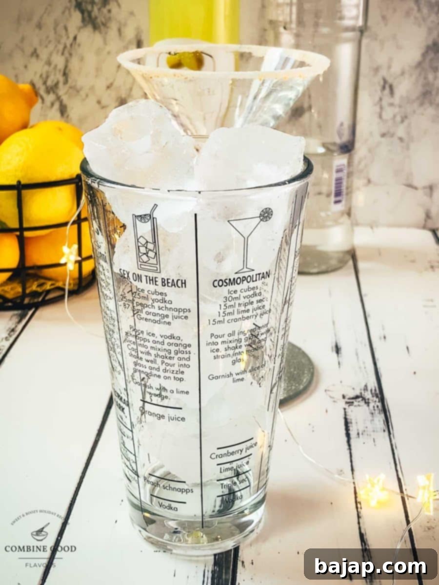 Glass cocktail shaker filled with cubed ice.