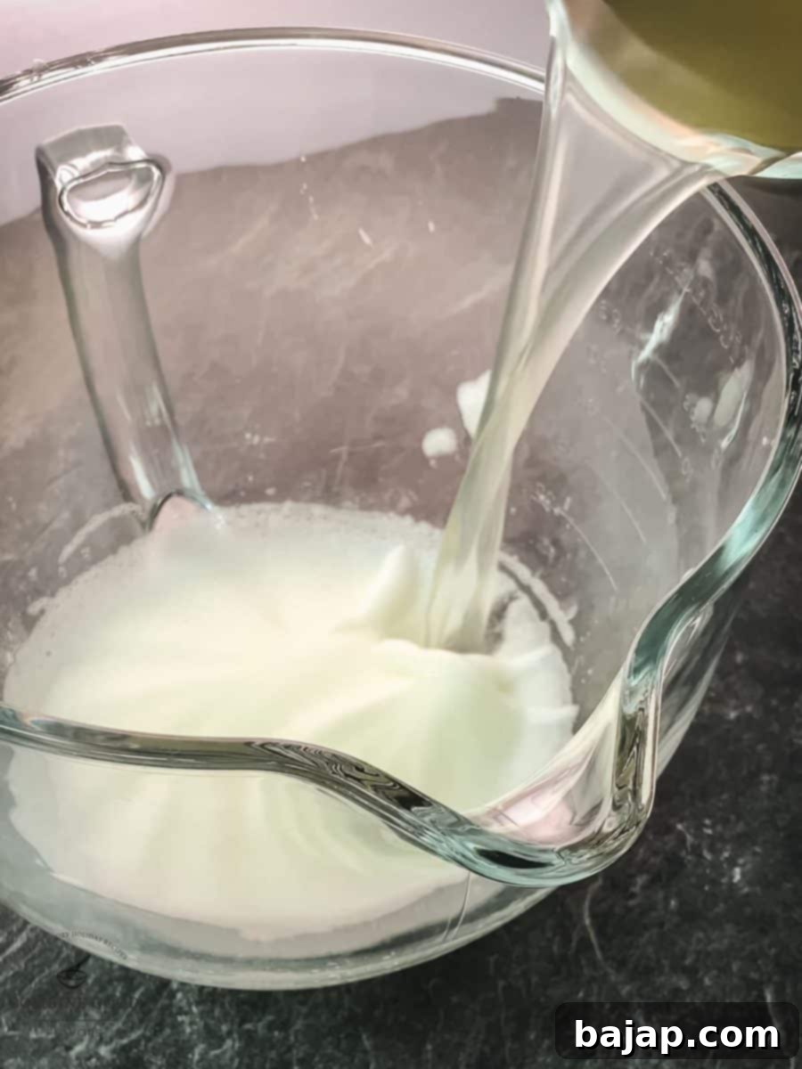 Pouring the lemon juice to the whipped egg white.