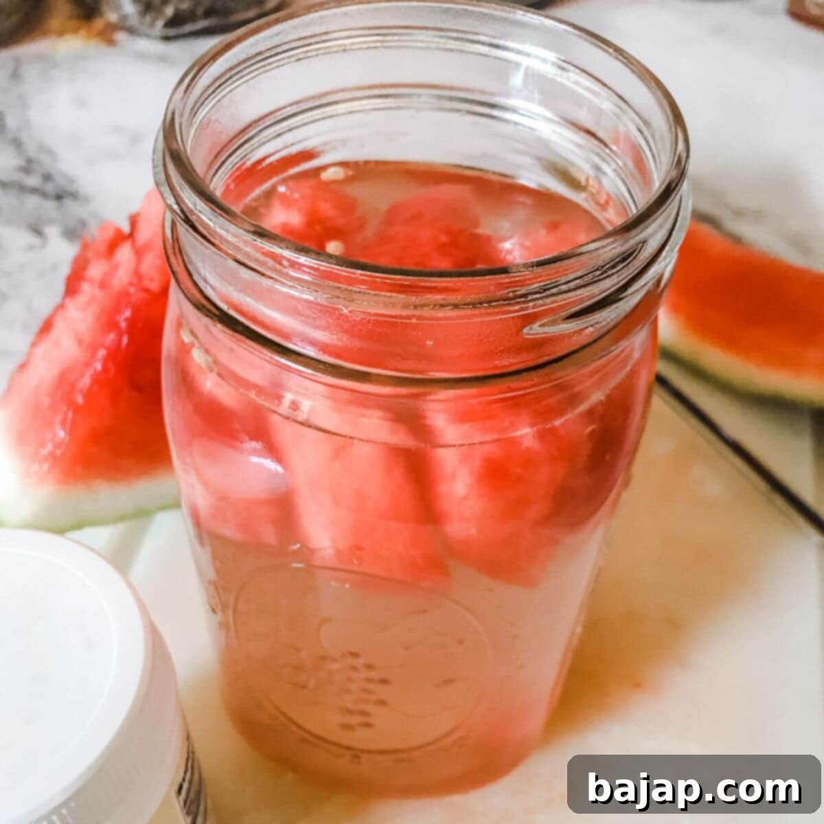 A glass of homemade watermelon electrolyte drink, garnished with a lime slice, perfect for hydration.