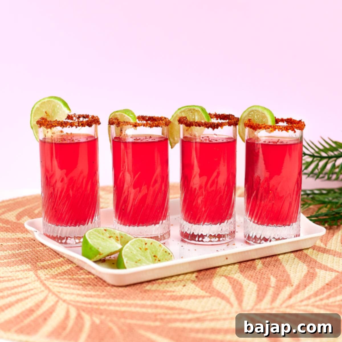 Vibrant Mexican Candy Jello Shots with watermelon jello, tequila, and a Tajin rim, arranged on a tray.