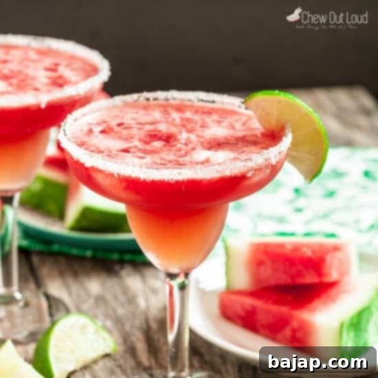 Two glasses of refreshing watermelon margaritas with salt rims and lime garnishes, ready to enjoy.