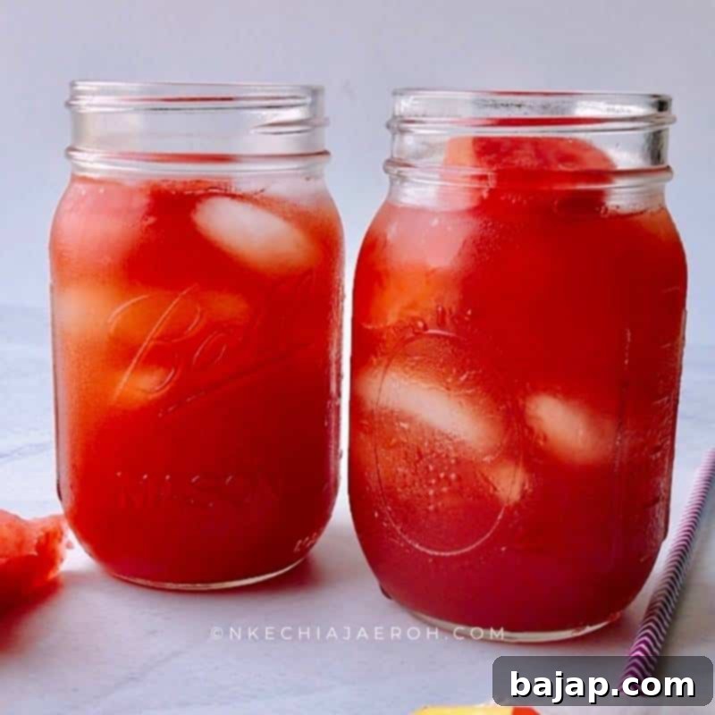 A tall glass of homemade watermelon iced tea with ice and fresh watermelon chunks, perfect for summer.