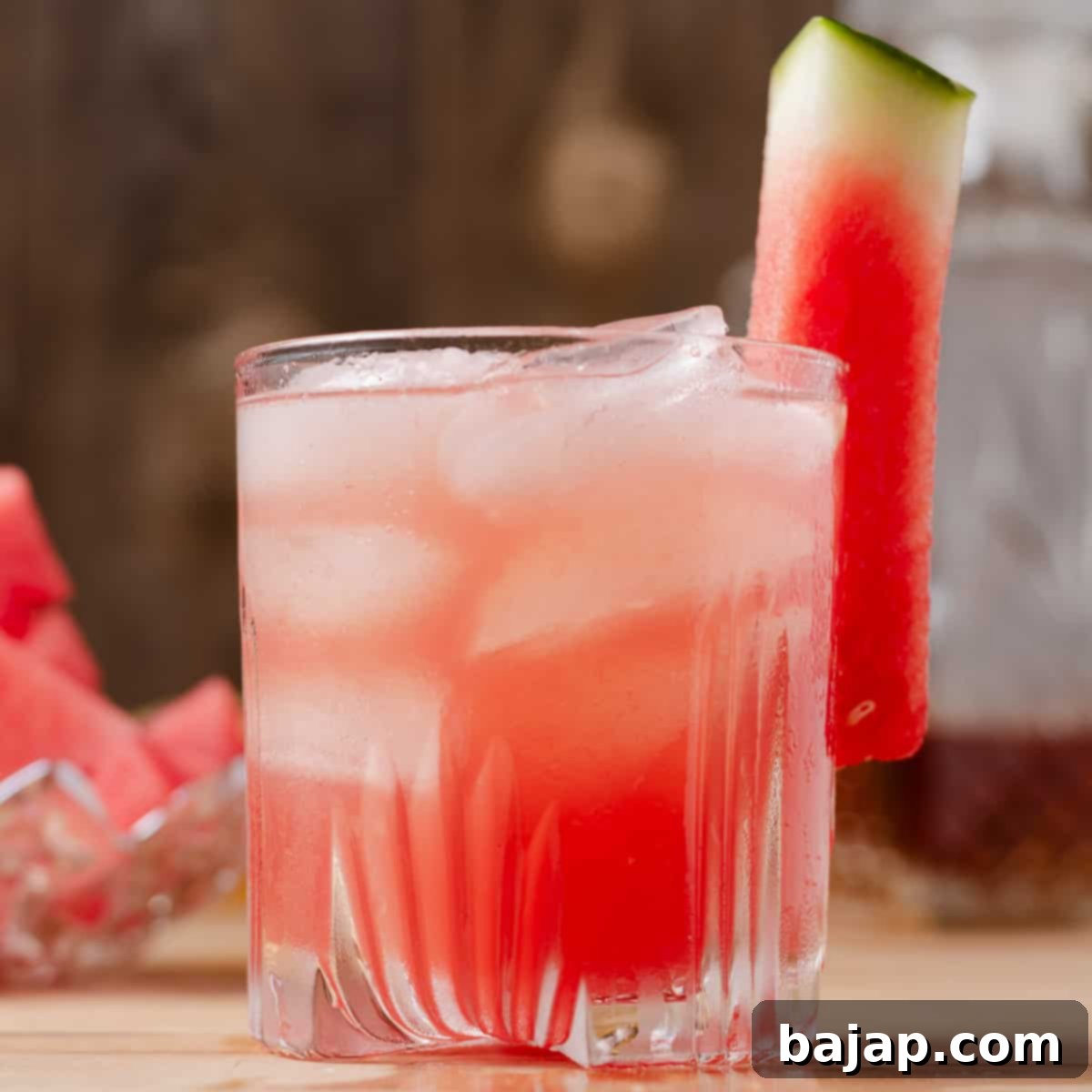 A sophisticated watermelon whiskey sour cocktail, beautifully presented in a glass with a lime wheel garnish.