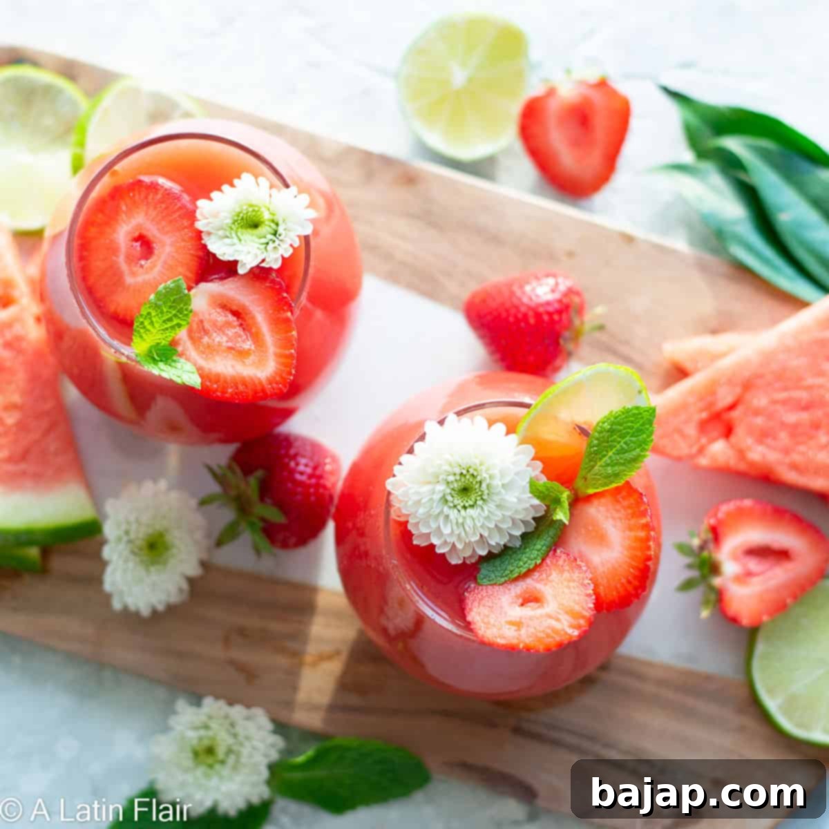 A glass of refreshing Strawberry Watermelon Rosé Sangria, garnished with fresh berries and a mint sprig.