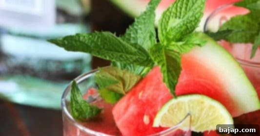 A refreshing easy watermelon mojito cocktail in a glass with mint and lime garnishes.