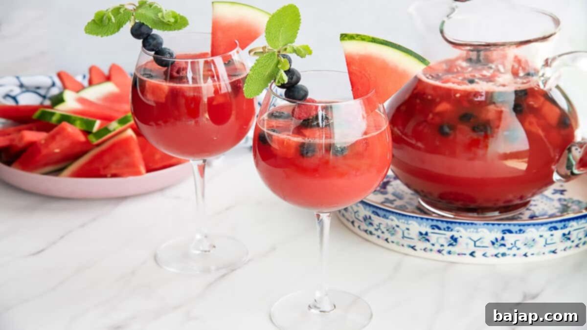 A pitcher of vibrant watermelon sangria filled with fresh fruit slices and mint, ready to serve.