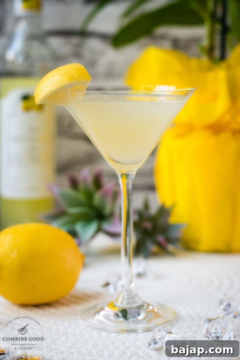 Gorgeous cocktail glass filled with a vibrant limoncello martini, garnished with a lemon wedge.