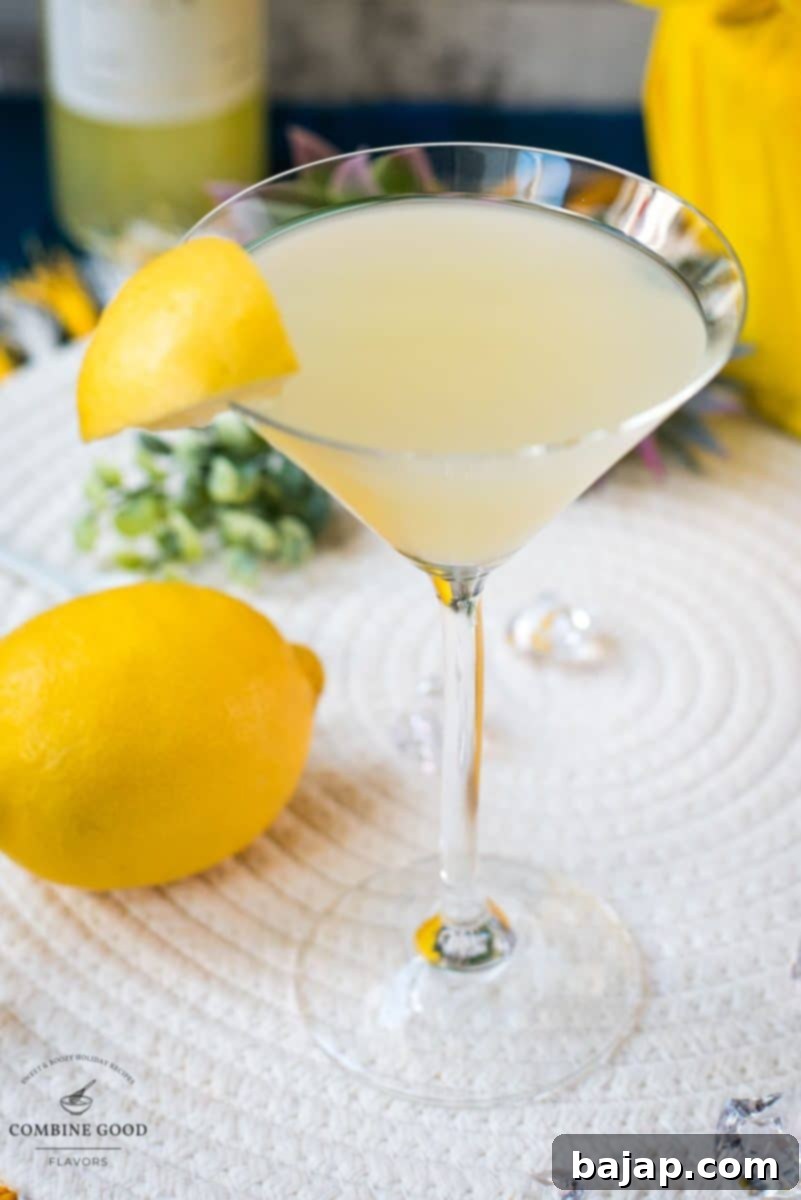 Gorgeous cocktail glass filled with a vibrant limoncello martini, garnished with a lemon wedge.