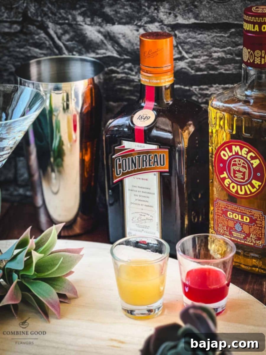Essential ingredients for a raspberry margarita: a bottle of premium tequila, Cointreau, fresh limes, and a jar of homemade raspberry syrup, all arranged invitingly.