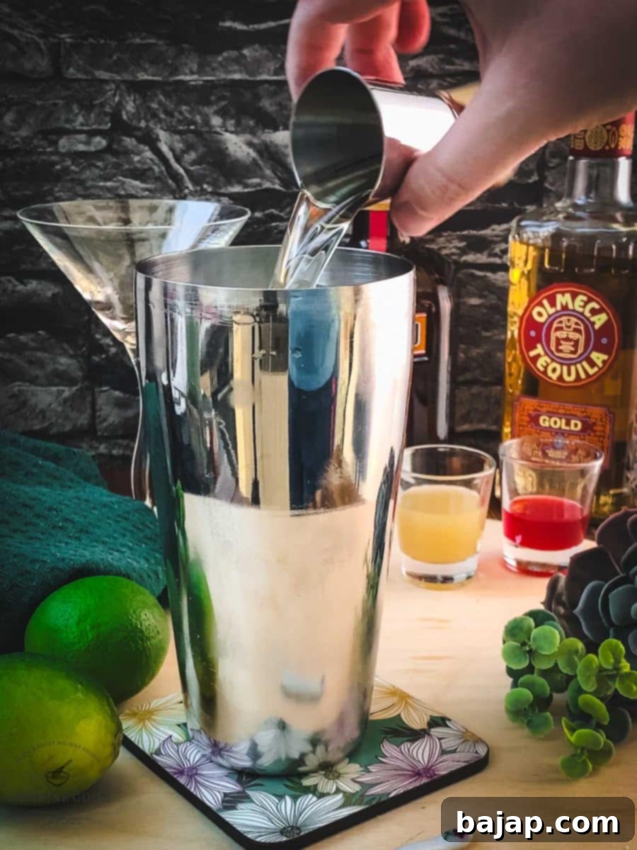 Pouring quality Tequila into a cocktail shaker as the first spirit.