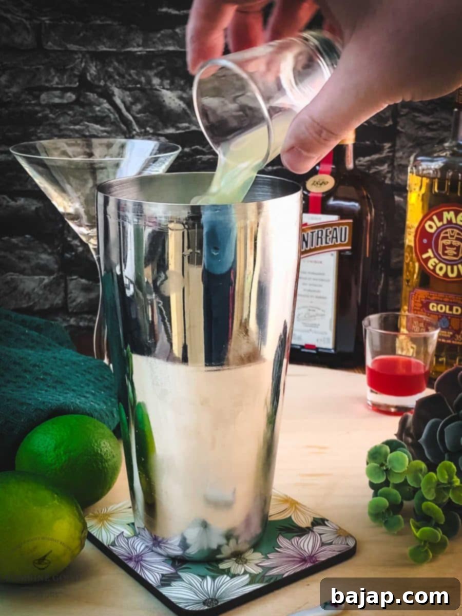 Squeezing fresh lime juice directly into the cocktail shaker for ultimate freshness.