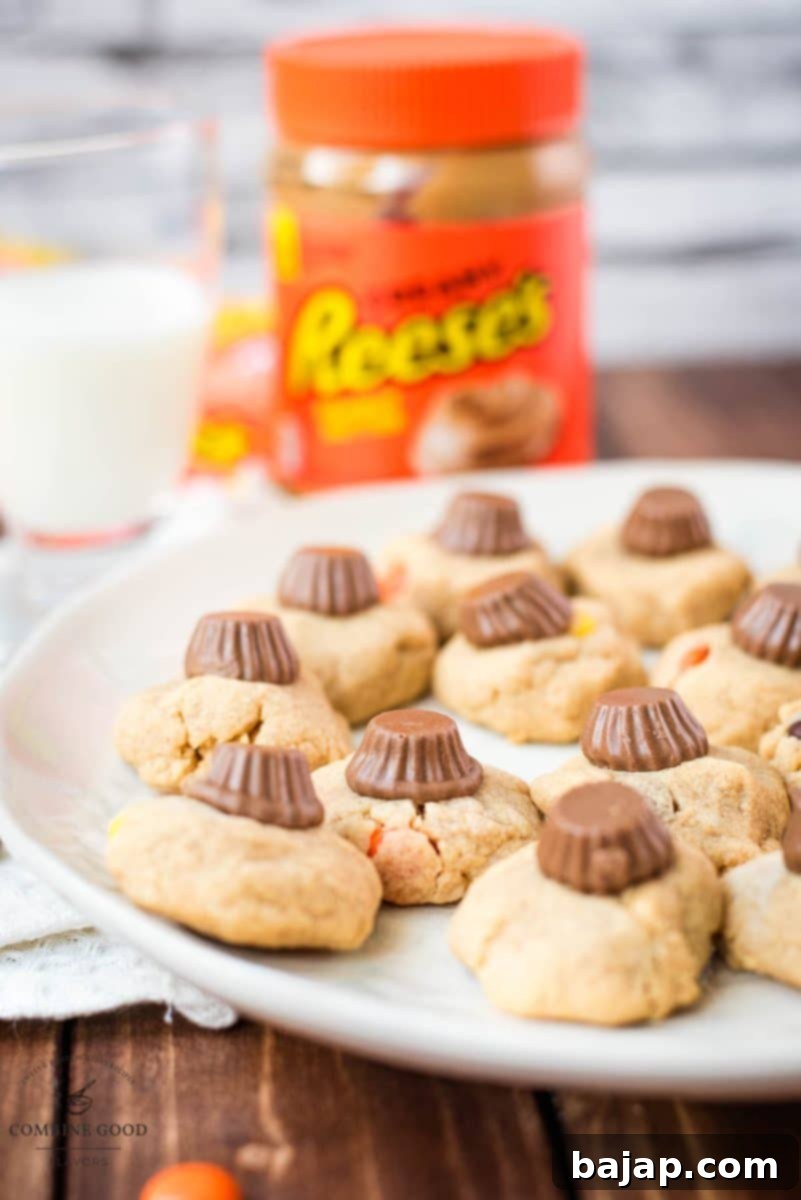 Utterly delicious Reese's peanut butter cookies served on a white plate, with a Reese's peanut butter mini cup on top.