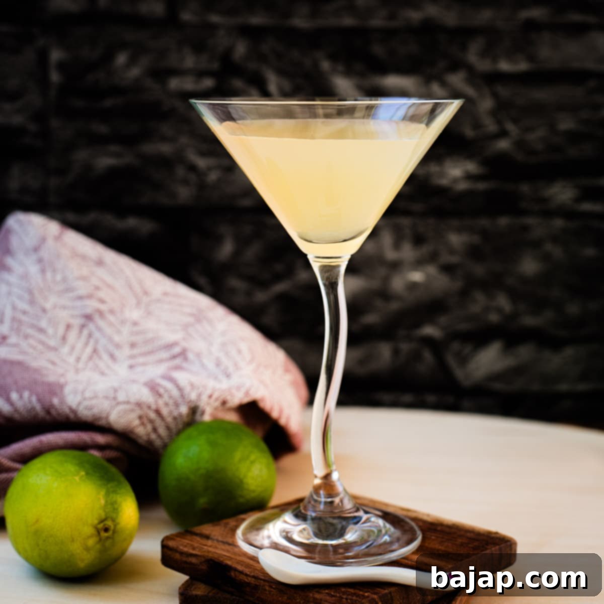 Gorgeous colored daiquiri in cocktail glass. Placed on a wooden board and dark wooden coaster.