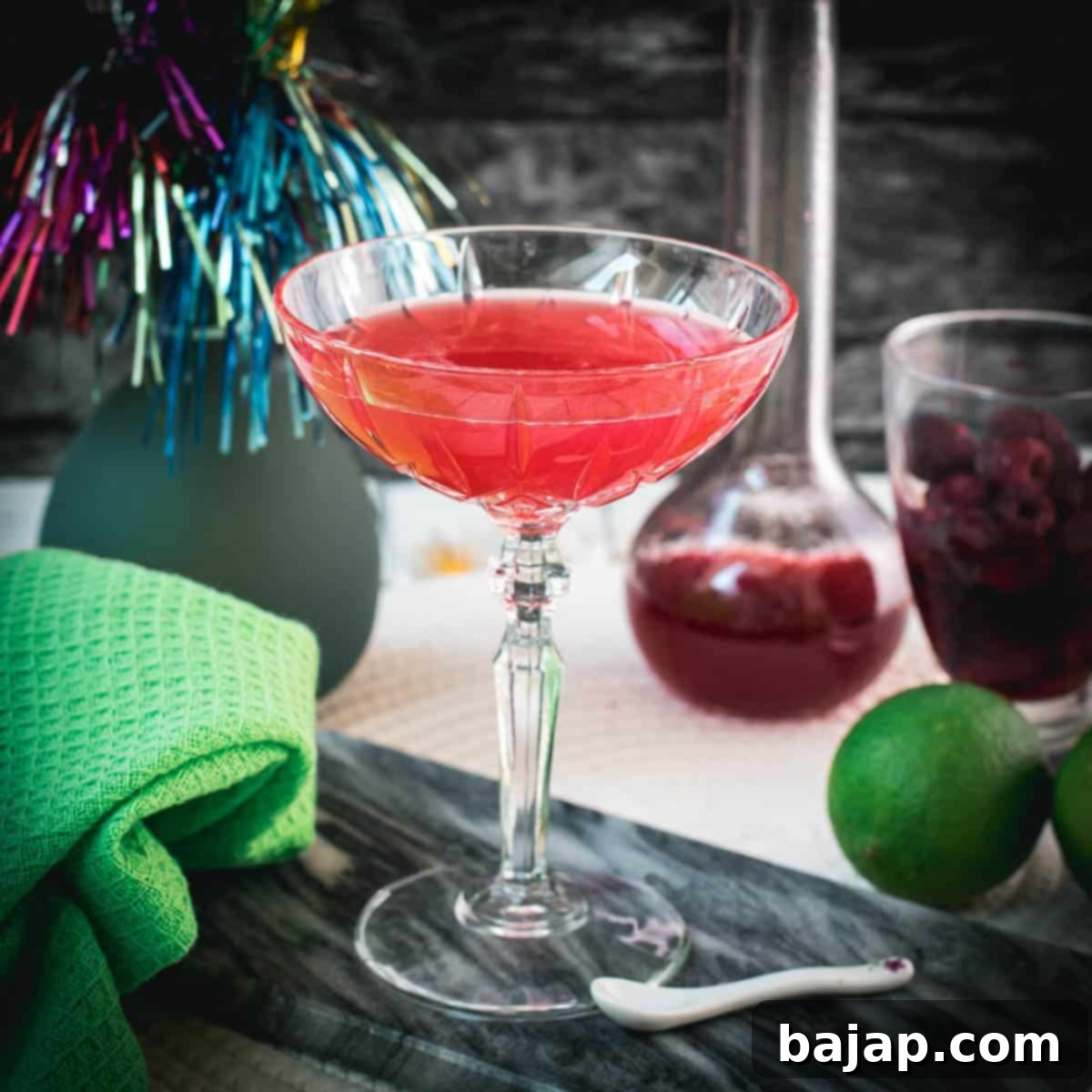Gorgeous raspberry daiquiri with a vibrant red color placed on marble plate.