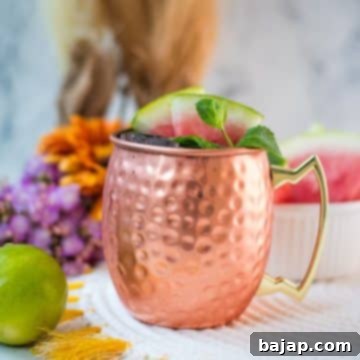 Gorgeous copper mug, filled with a delicious watermelon Moscow mule. Garnished with watermelon slices and mint leaves.