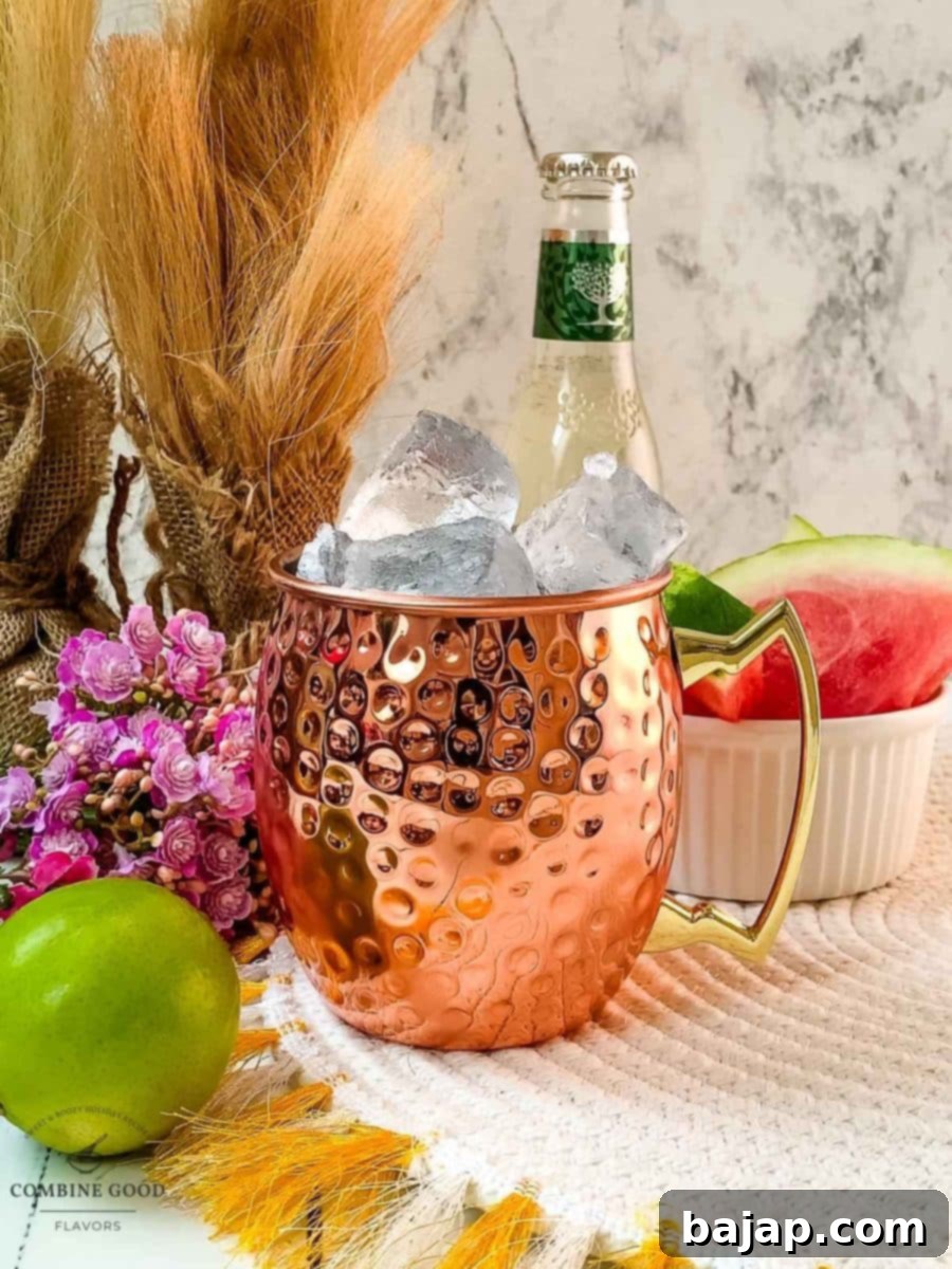 Filling the copper mug generously with cubed ice, ensuring a perfectly chilled Watermelon Moscow Mule.