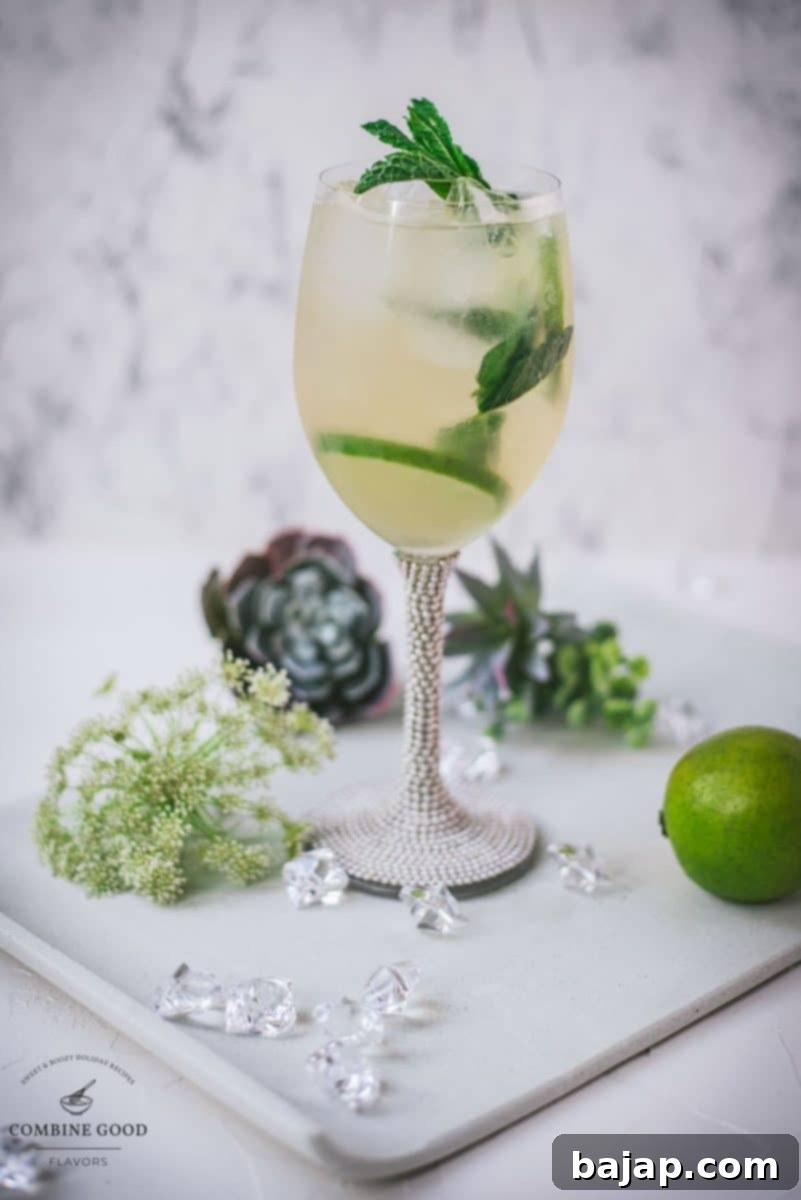 Refreshing White Wine Hugo Spritz Recipe 10 A perfectly prepared Hugo Spritz cocktail in a wine glass, garnished with mint and lime, resting on a white plate, ready to be enjoyed.