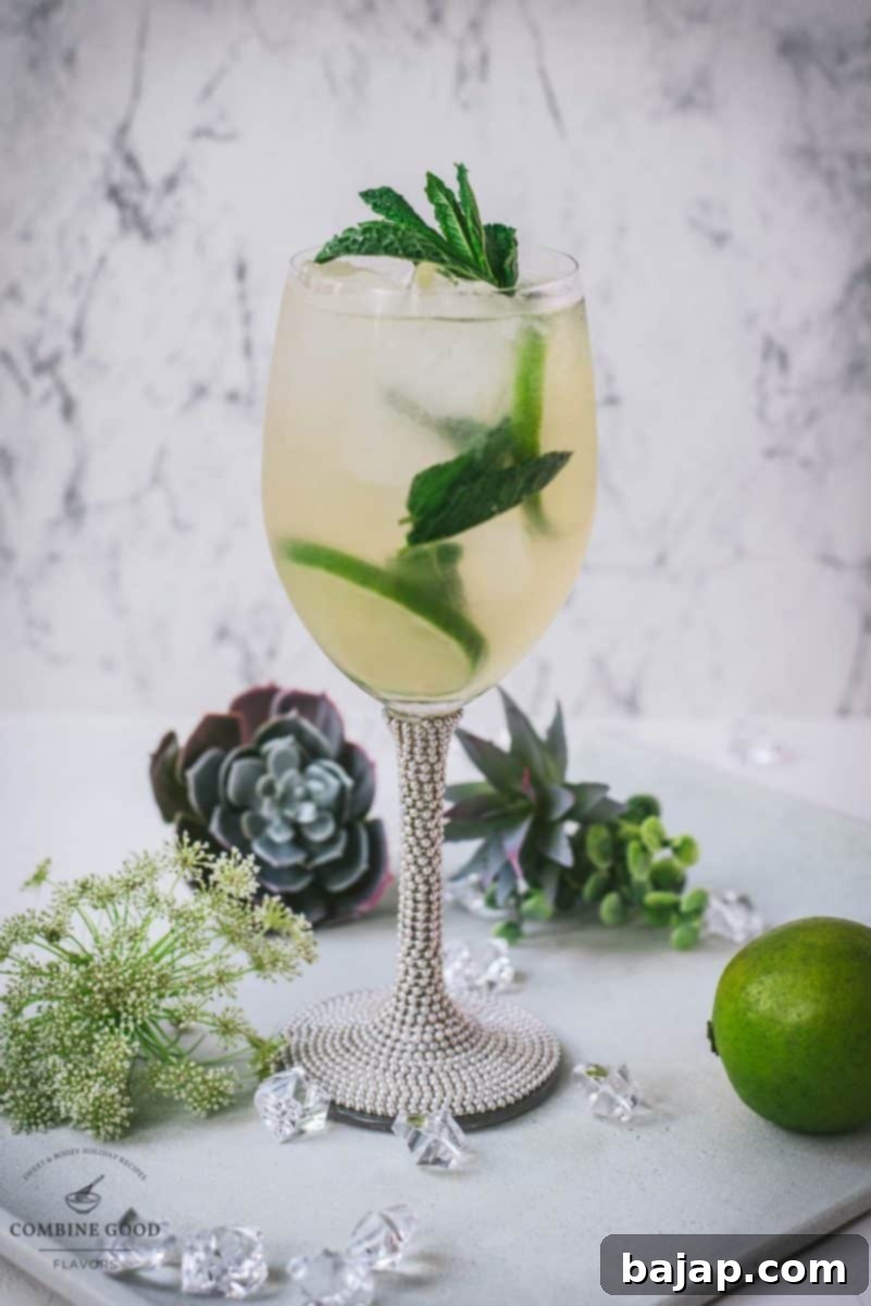 Refreshing White Wine Hugo Spritz Recipe 11 A stunning close-up of a Hugo Spritz cocktail in a wine glass, garnished with fresh mint and lime, with soft background lighting.