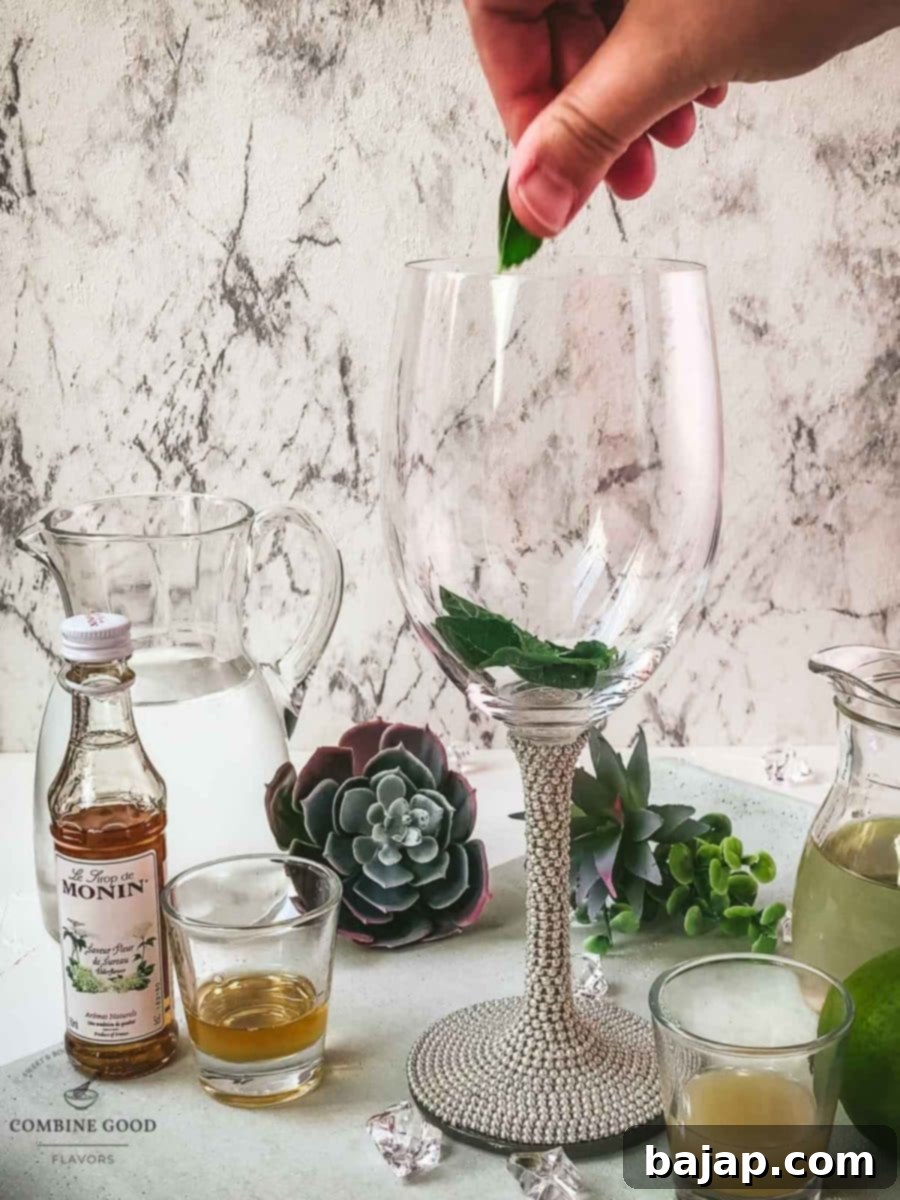 Refreshing White Wine Hugo Spritz Recipe 4 Gently rubbing fresh mint leaves between fingers to release their essential oils before adding them to a wine glass, enhancing the aroma of the Hugo cocktail.