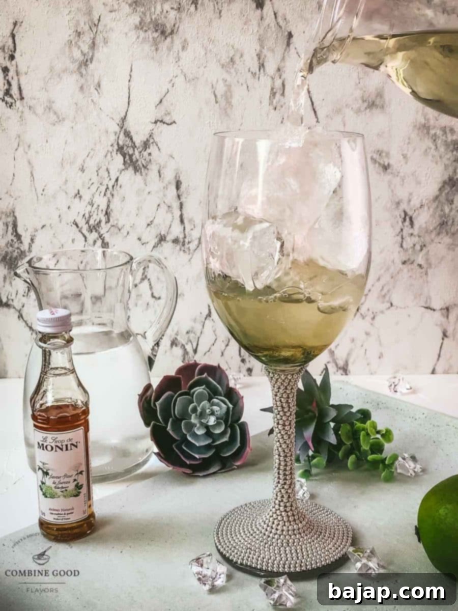 Refreshing White Wine Hugo Spritz Recipe 6 Carefully pouring dry white wine into the wine glass, which contains mint, ice, lime juice, and elderflower syrup, creating the core of the Hugo Spritz.
