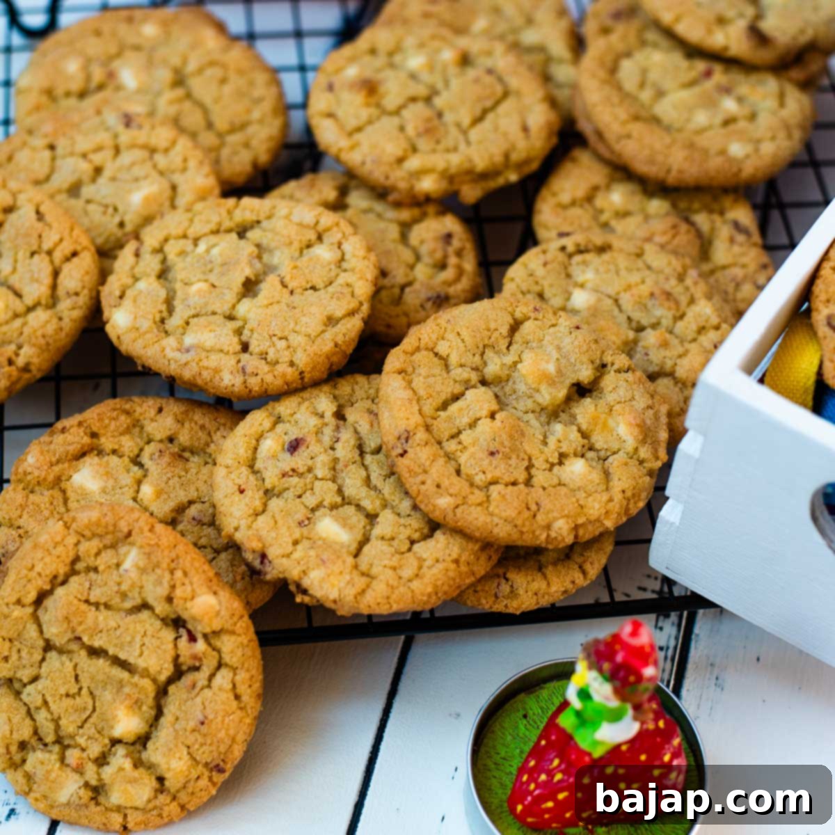 Soft, chewy and sweet strawberry cookies with white chocolate chips scattered on a cooling rack.