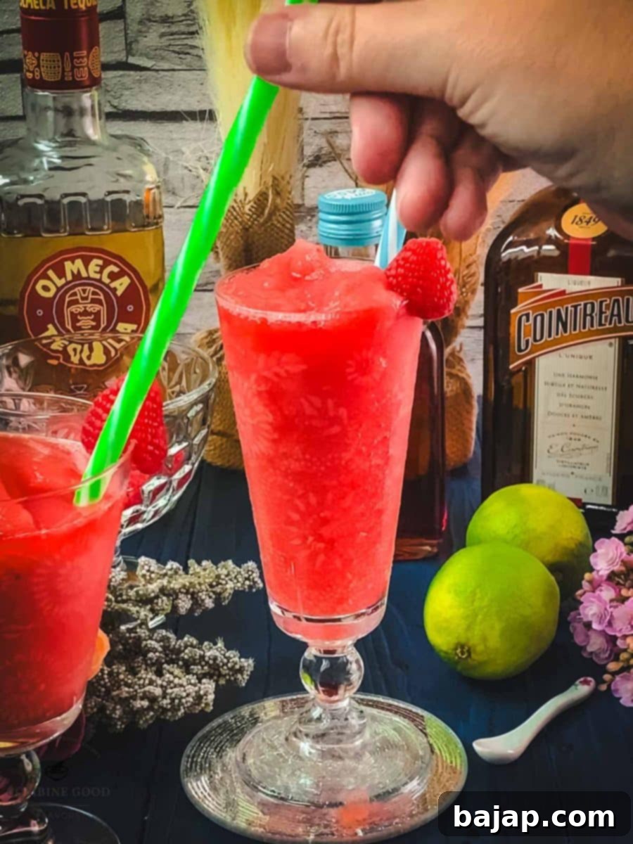 Raspberry Chill Margarita 12 Serving the finished frozen raspberry margarita with a drinking straw for easy and enjoyable sipping.