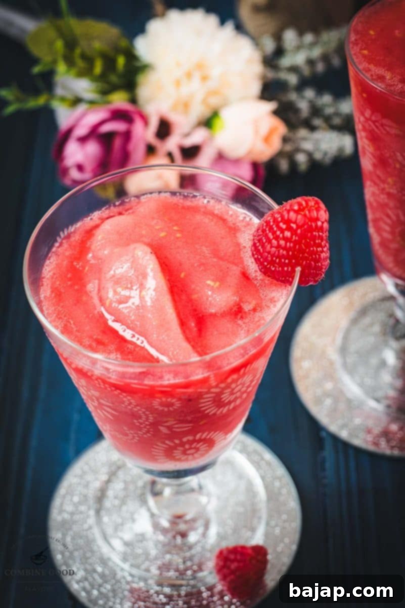 Raspberry Chill Margarita 13 Two gorgeous glasses filled with a delicious frozen raspberry margarita cocktail, perfectly garnished and ready to be enjoyed on a sunny day.