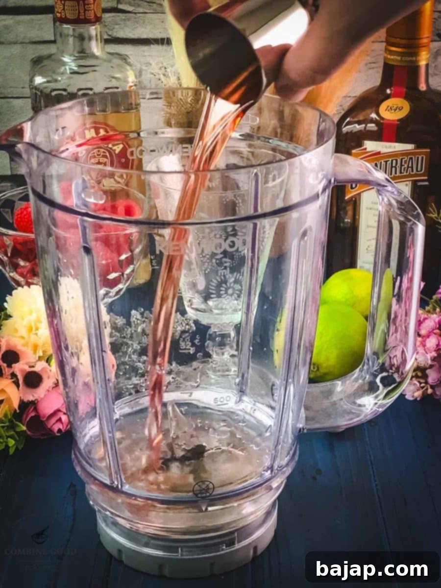 Raspberry Chill Margarita 5 Pouring homemade raspberry syrup or Chambord into the blender for enhanced berry flavor in the frozen margarita.