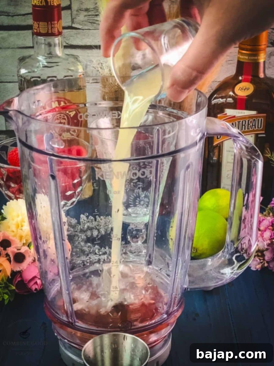 Raspberry Chill Margarita 6 Squeezing fresh lime juice into the blender to add essential tartness to the frozen raspberry margarita mix.