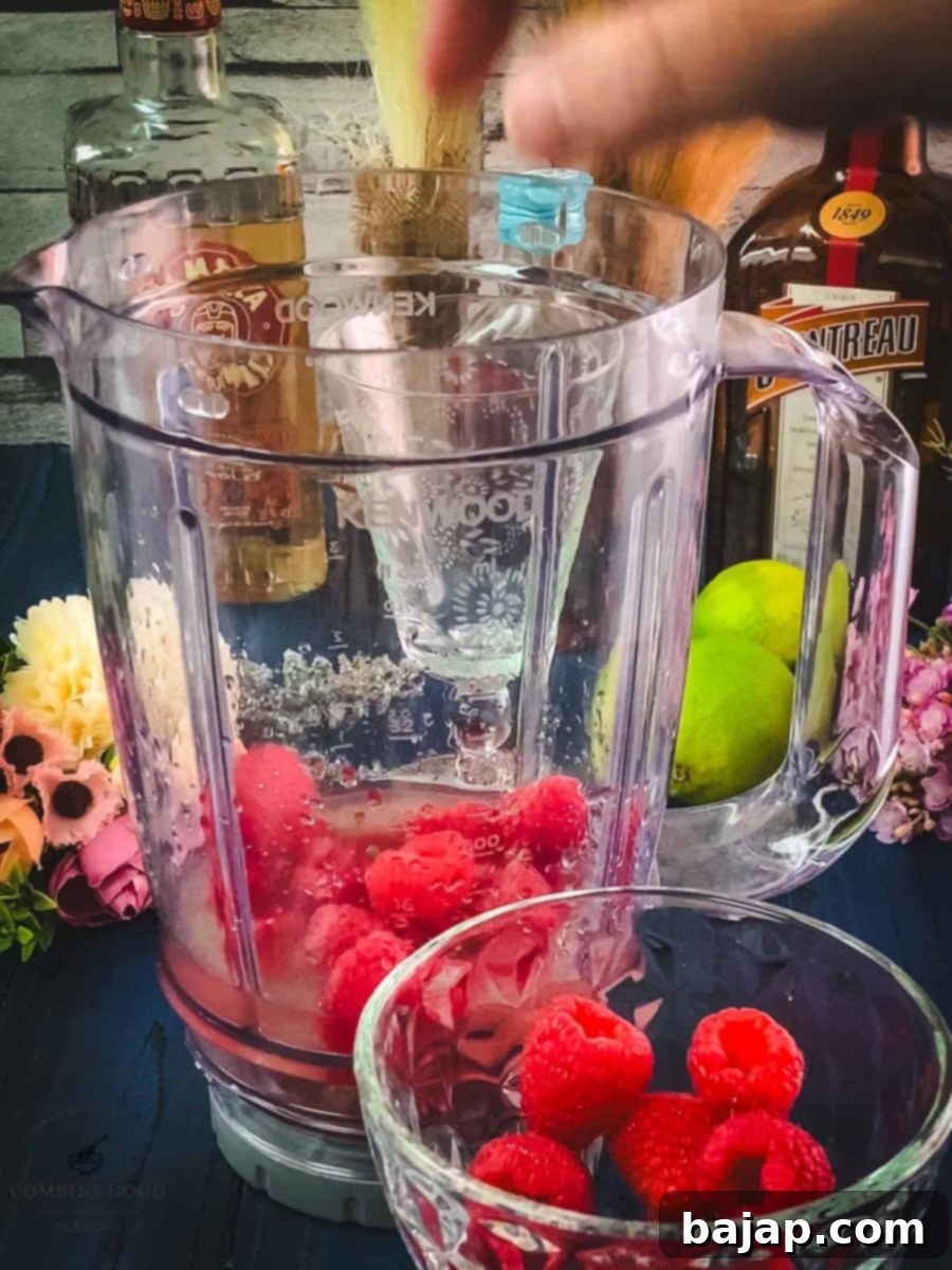 Raspberry Chill Margarita 7 Adding a generous handful of fresh raspberries to the blender for intense fruity flavor and vibrant color.