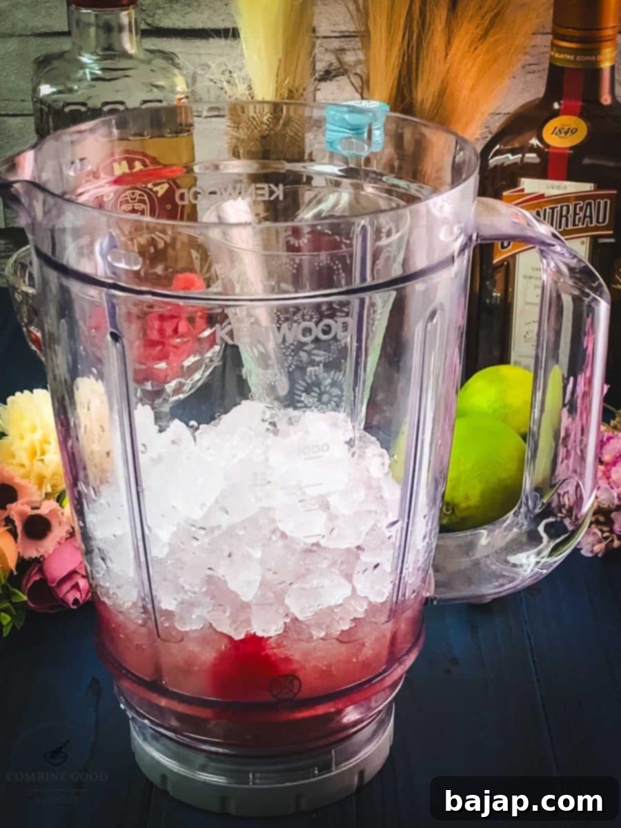 Raspberry Chill Margarita 8 Scooping crushed ice into the blender with the cocktail ingredients to create a perfect frozen consistency.