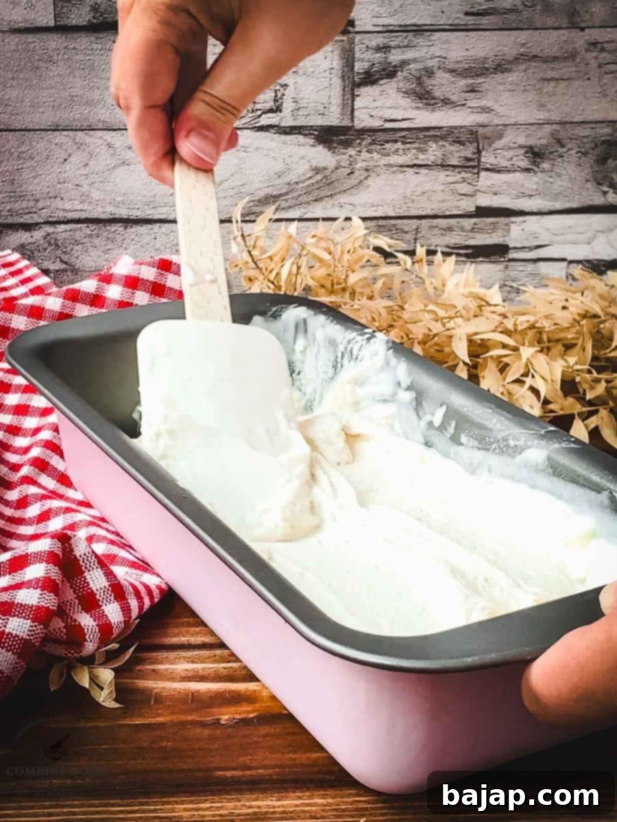 Spreading ice cream with a spatula into a loaf pan.