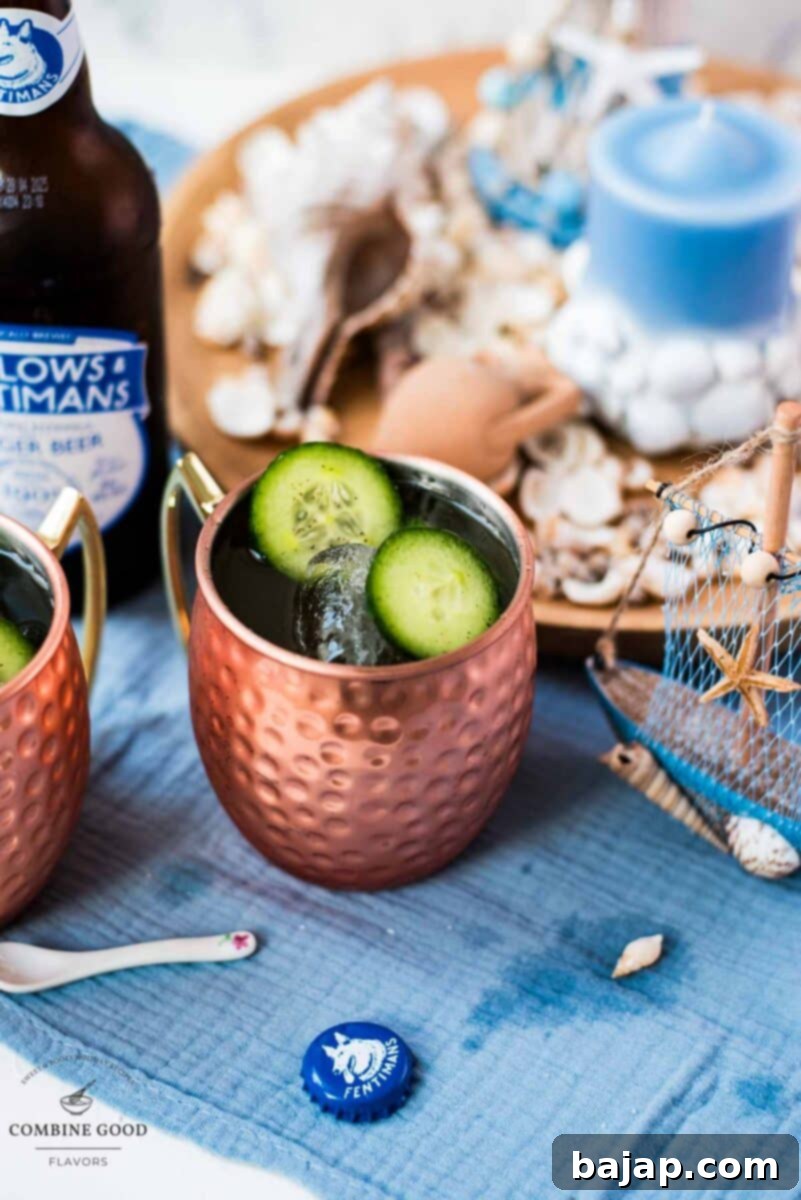 Refreshing mint cucumber Moscow mule served in gleaming copper mugs, placed on a white and blue surface, garnished with fresh mint and lime slices. A perfect summer drink.