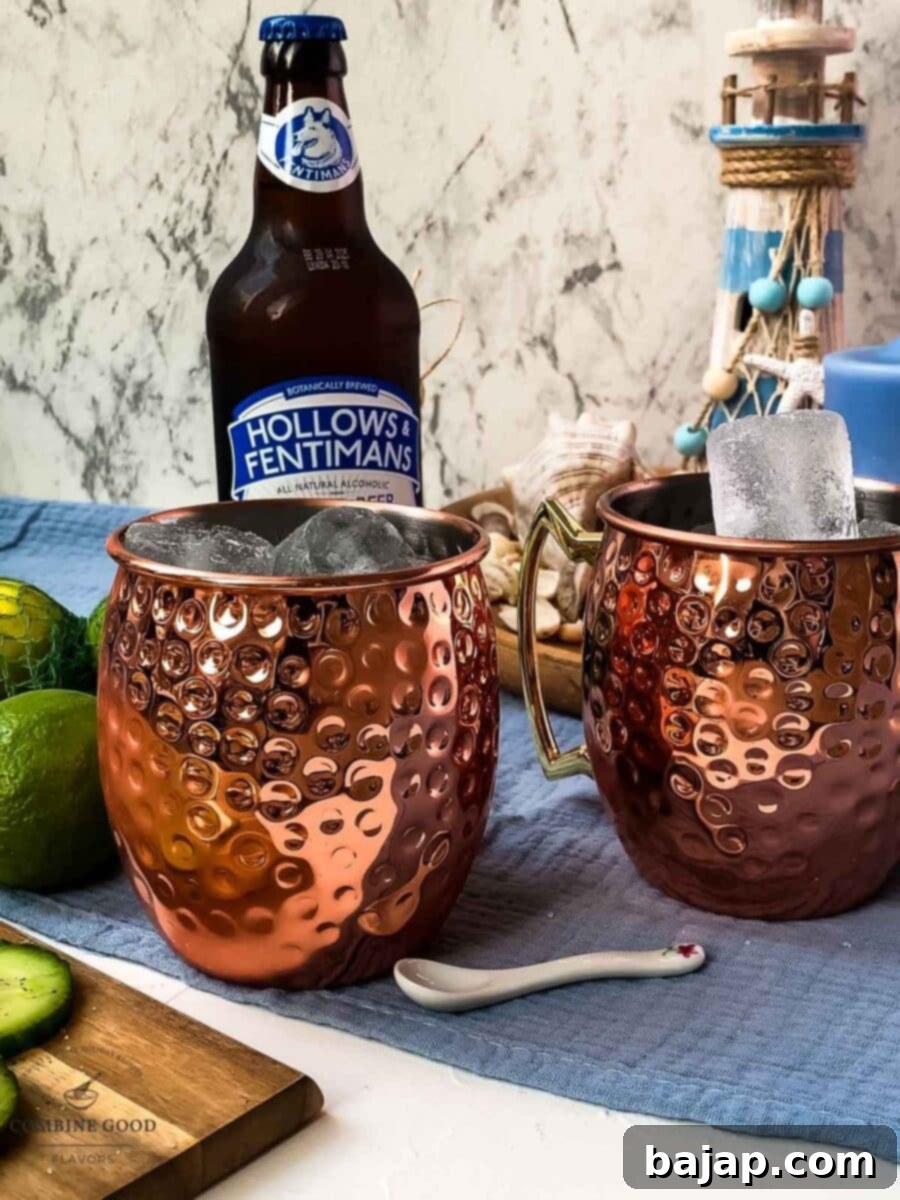 Filling a copper mug with cubed ice, preparing for a perfectly chilled Moscow Mule.