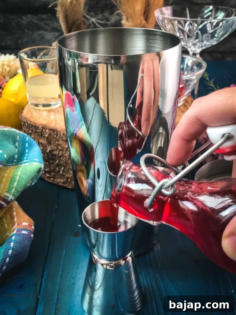 Measure homemade raspberry syrup using a jigger.