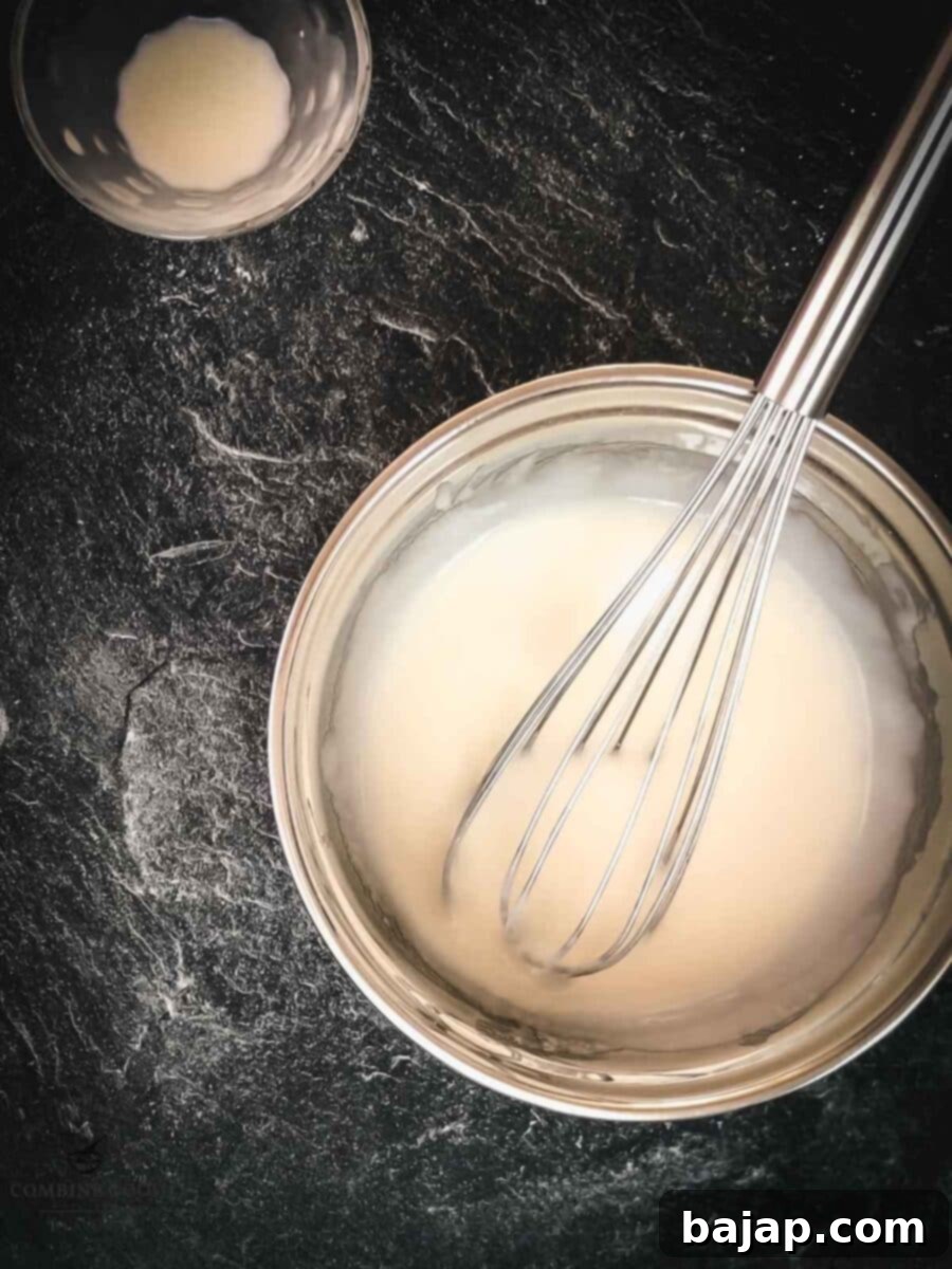 Whisk together powdered sugar, lemon juice, and rice milk for creating the glaze. Smooth and creamy for Halloween spiderweb cookies.