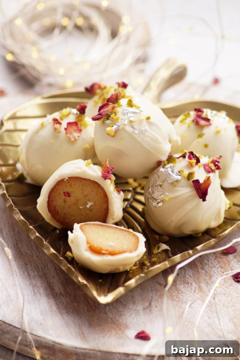 Soft, juicy Indian gulab jamuns covered with white chocolate, decorated with rose petals