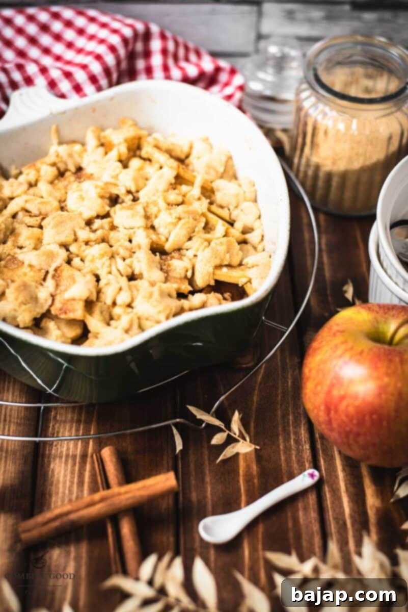 Casserole filled with freshly baked apple crisp on wooden ground, showcasing the golden, crunchy topping.