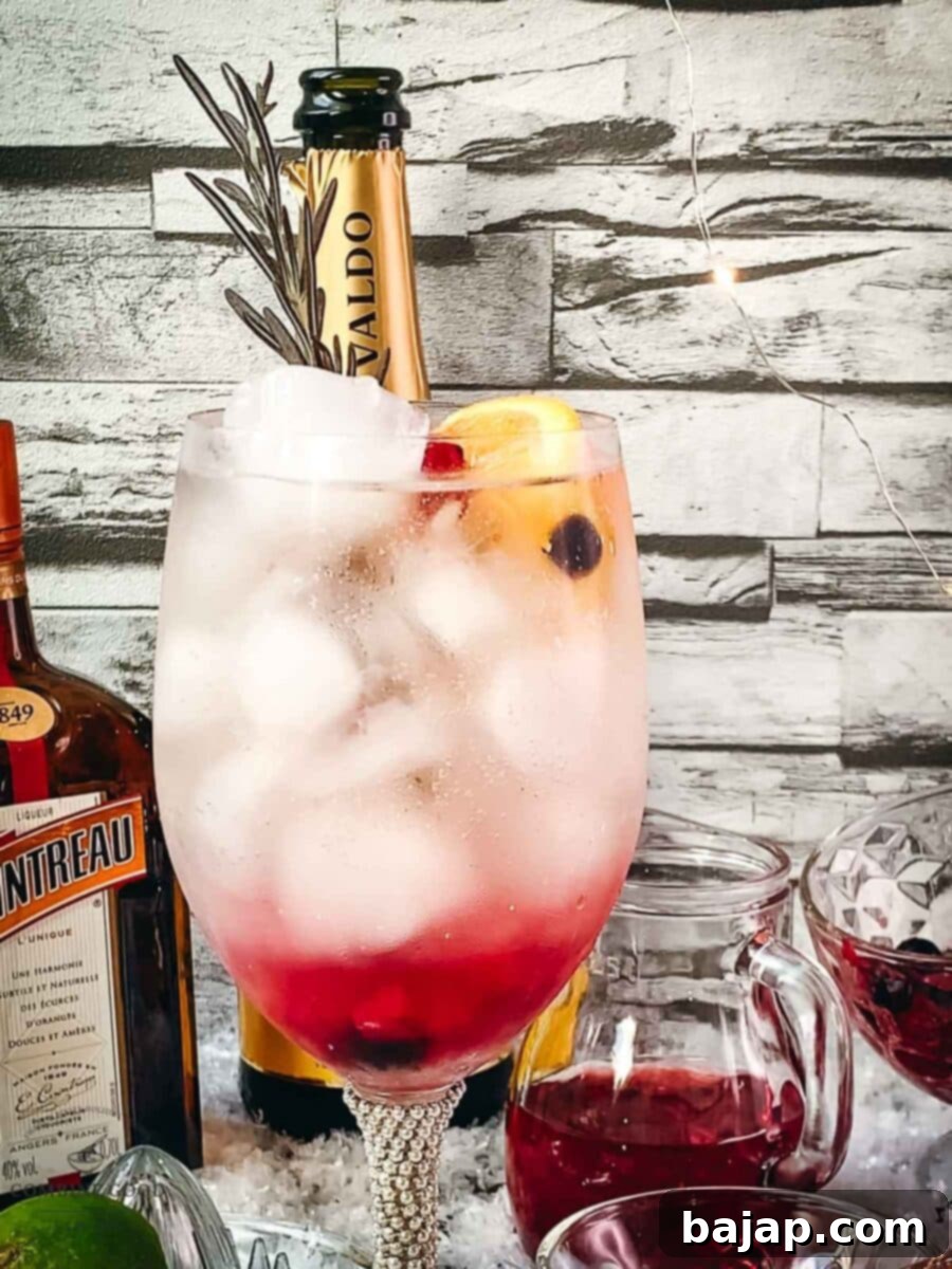 Adding a sprig of rosemary as a garnish to the Prosecco Cosmo cocktail.