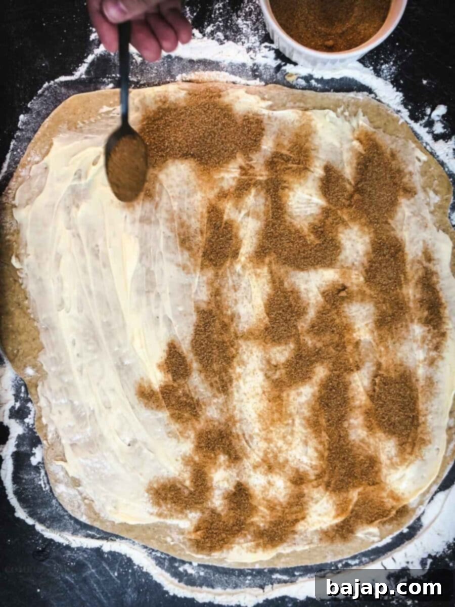 Mix the brown sugar and cinnamon, then sprinkle it evenly over the buttered dough.