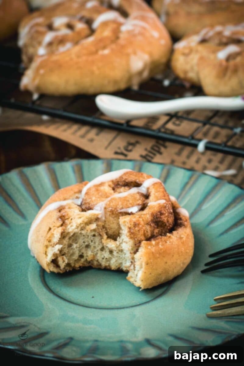 Yummy mini cinnamon rolls, drizzled with homemade sugar icing, placed on teal colored plate.